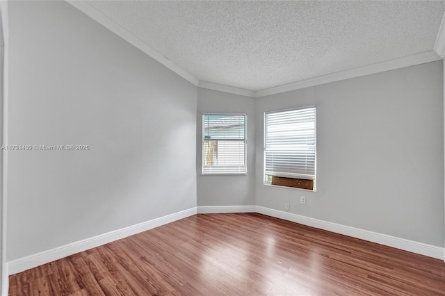 empty room with crown molding, wood-type flooring, and a textured ceiling