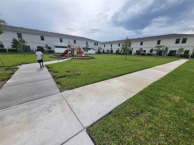 view of property's community featuring a lawn and a playground