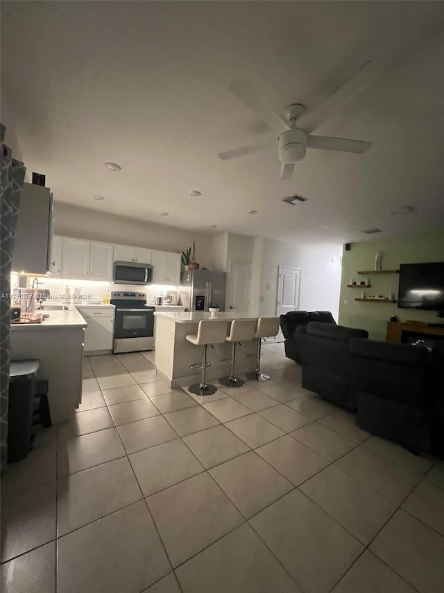 tiled living room with sink and ceiling fan