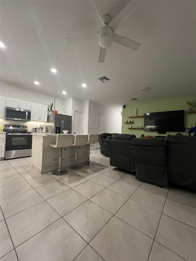 tiled living room featuring ceiling fan