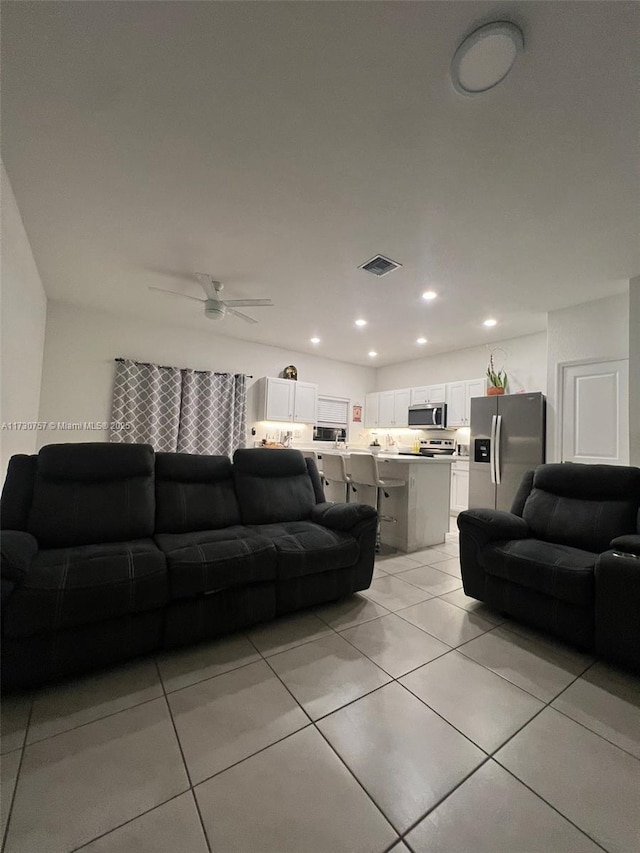 tiled living room with ceiling fan