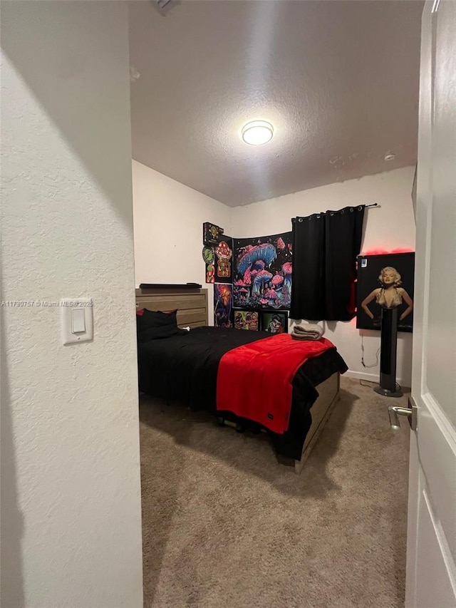 bedroom with carpet floors and a textured ceiling