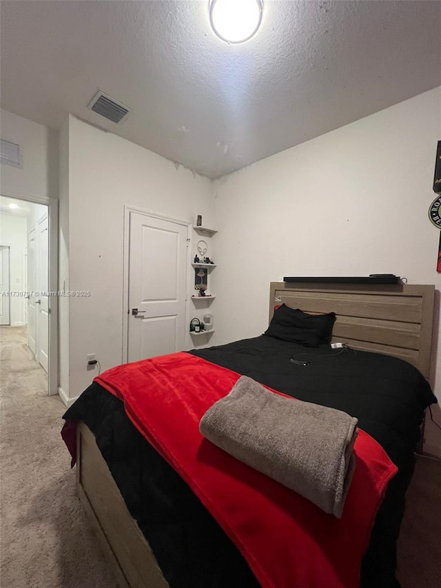 bedroom featuring a textured ceiling and carpet flooring