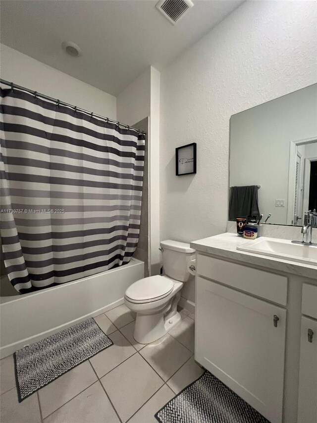 full bathroom with tile patterned flooring, shower / bath combo, vanity, and toilet