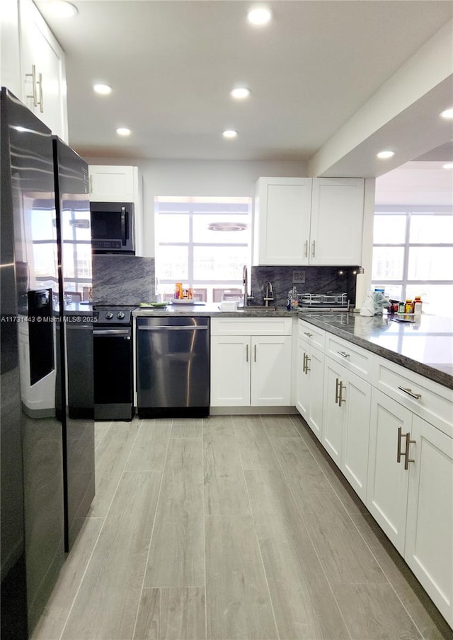 kitchen with white cabinetry, sink, backsplash, and stainless steel appliances