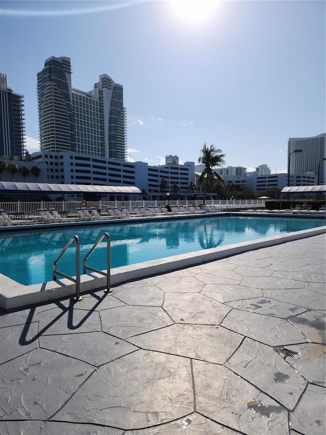 view of swimming pool featuring cooling unit and a patio