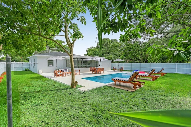 view of swimming pool featuring a yard, glass enclosure, and a patio area