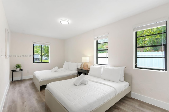 bedroom featuring multiple windows and light wood-type flooring