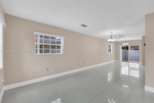2050 NE 140th St Unit 1, North Miami Beach, FL 33181 - empty room featuring a chandelier, baseboards, tile patterned floors, and a textured ceiling