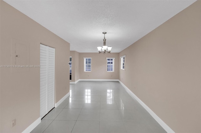 interior space with light tile patterned floors, a textured ceiling, and an inviting chandelier