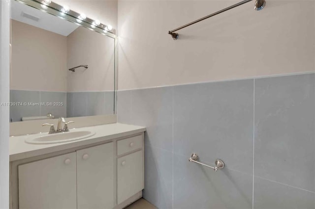 bathroom with vanity and tile walls