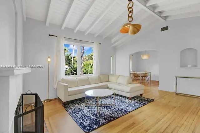 living room featuring lofted ceiling with beams and hardwood / wood-style flooring