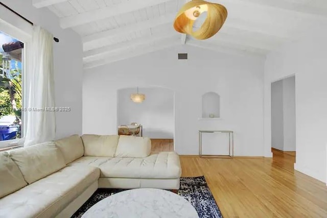 living room featuring wood-type flooring and vaulted ceiling with beams