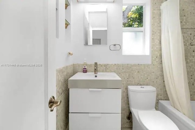 full bathroom featuring vanity, shower / bathtub combination with curtain, and toilet