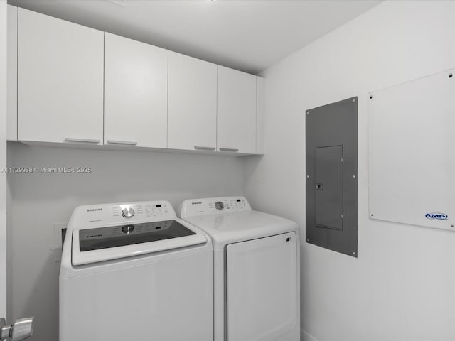 clothes washing area with cabinets, electric panel, and washer and dryer