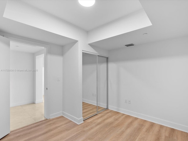 unfurnished bedroom with a closet and light hardwood / wood-style flooring