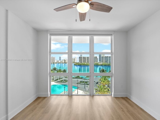 empty room featuring a water view and light hardwood / wood-style floors