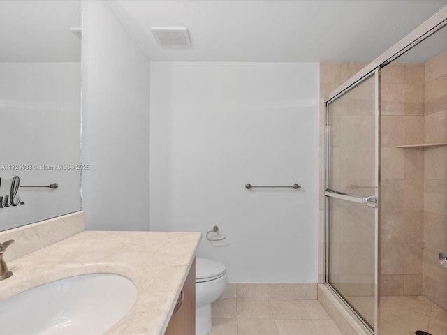 bathroom featuring tile patterned floors, toilet, a shower with door, and vanity