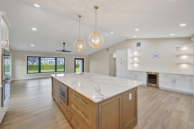 kitchen featuring a spacious island, white cabinetry, vaulted ceiling, pendant lighting, and beverage cooler