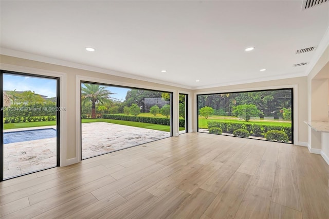 empty room featuring ornamental molding and light hardwood / wood-style floors