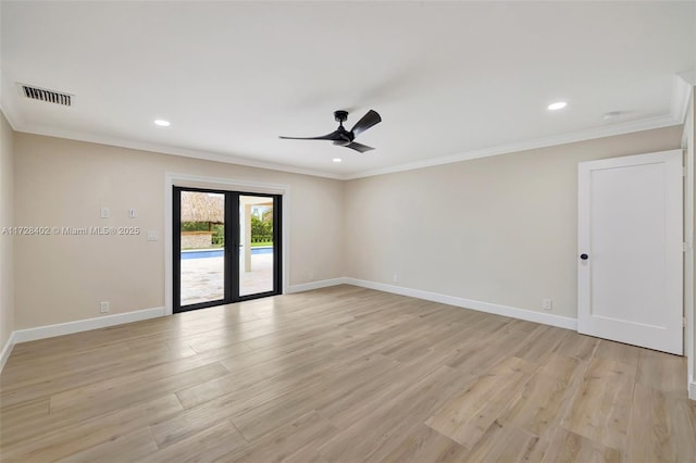 spare room featuring light hardwood / wood-style flooring, ornamental molding, and french doors