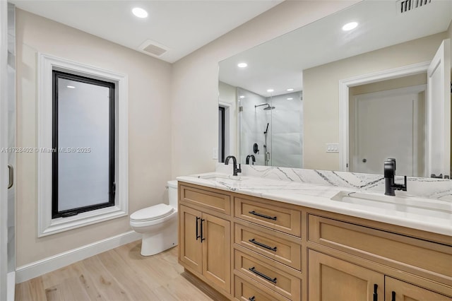 bathroom with hardwood / wood-style flooring, vanity, an enclosed shower, and toilet