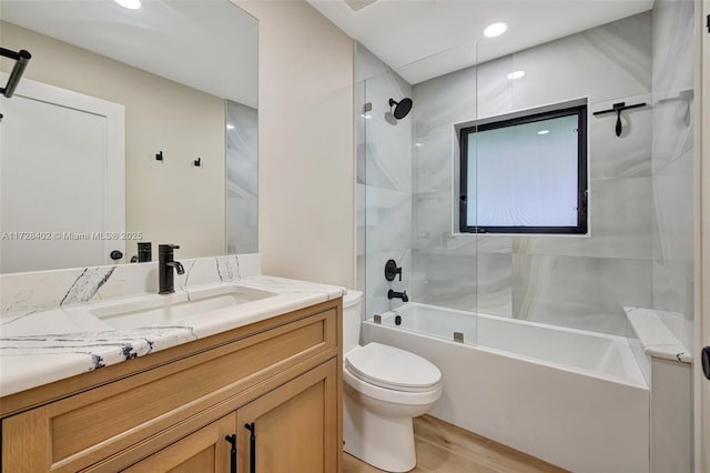 full bathroom featuring vanity, toilet, tiled shower / bath combo, and wood-type flooring