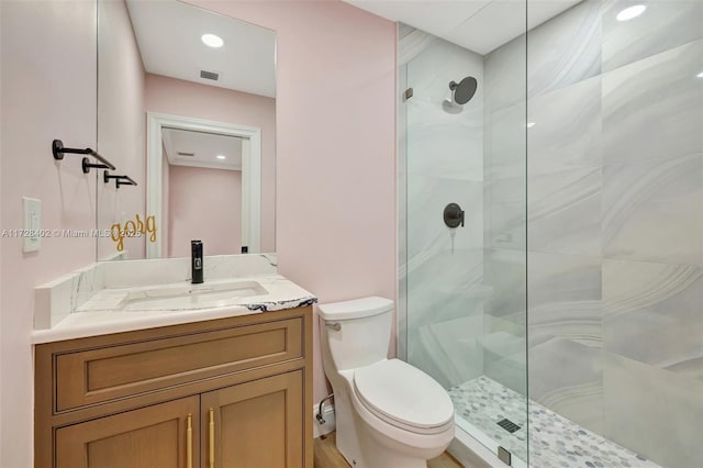 bathroom featuring vanity, toilet, and a shower with shower door