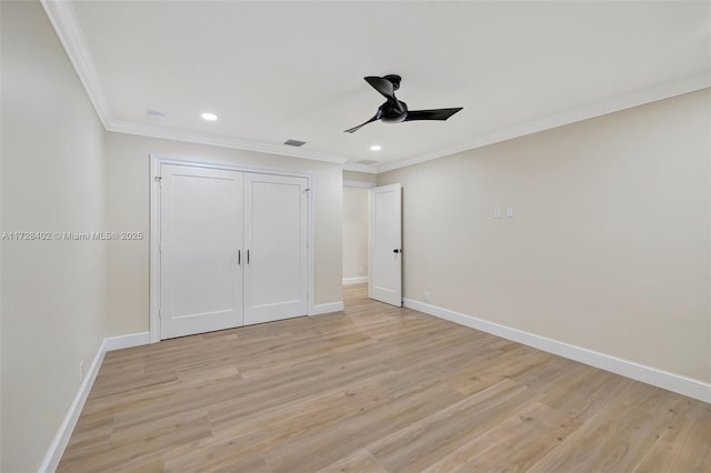 unfurnished bedroom featuring crown molding, light wood-type flooring, ceiling fan, and a closet