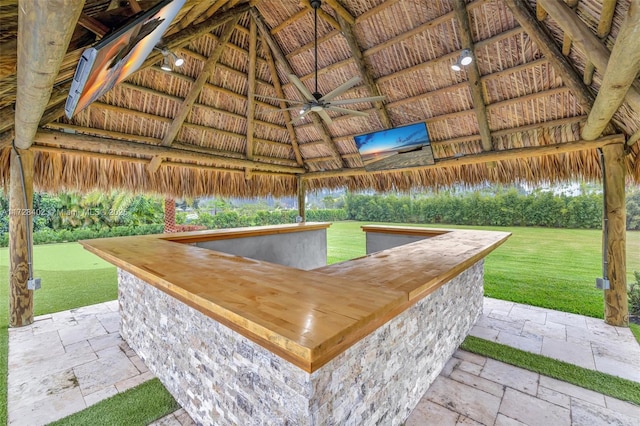 view of patio featuring a gazebo, ceiling fan, and a bar