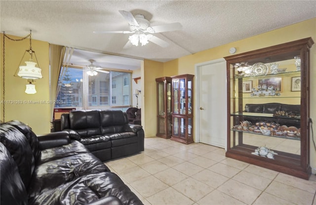 living room featuring ceiling fan, a textured ceiling, and light tile patterned flooring