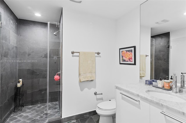 bathroom featuring vanity, a shower with shower door, tile patterned floors, and toilet