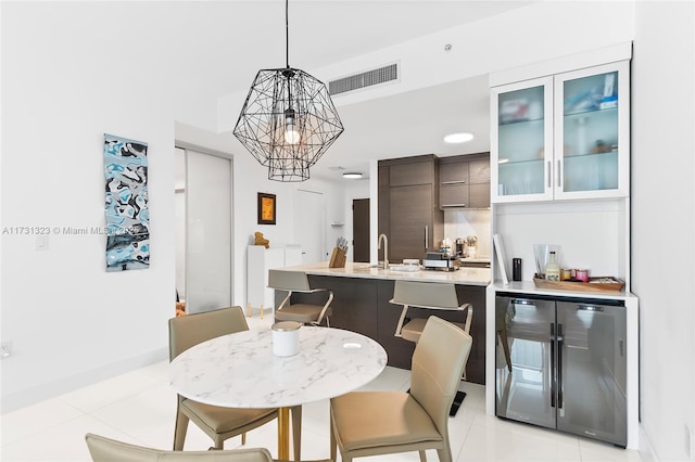 tiled dining room with sink, beverage cooler, and a chandelier