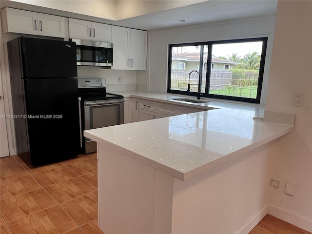 kitchen with sink, light stone counters, kitchen peninsula, stainless steel appliances, and white cabinets