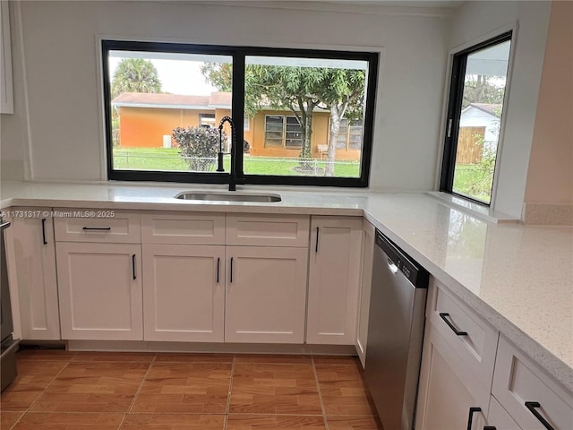 kitchen featuring sink, light tile patterned floors, white cabinets, and dishwasher