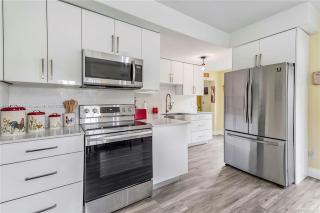 kitchen featuring white cabinetry, appliances with stainless steel finishes, sink, and light hardwood / wood-style flooring