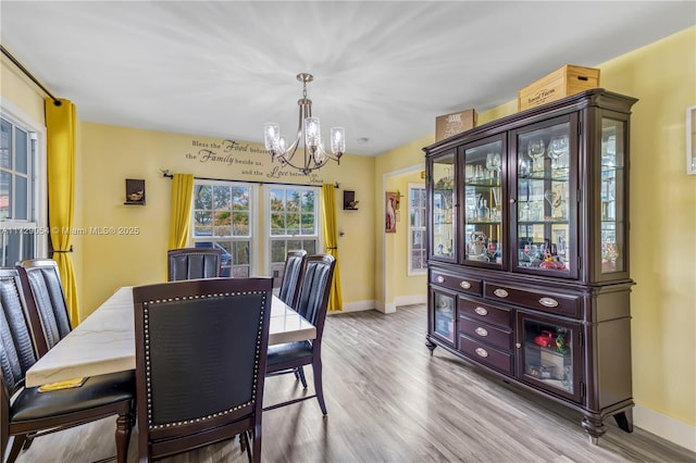 dining room with light hardwood / wood-style flooring and a notable chandelier