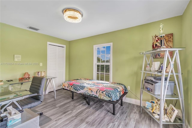 bedroom with light hardwood / wood-style floors and a closet