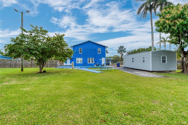 view of yard featuring a fenced in pool and an outdoor structure