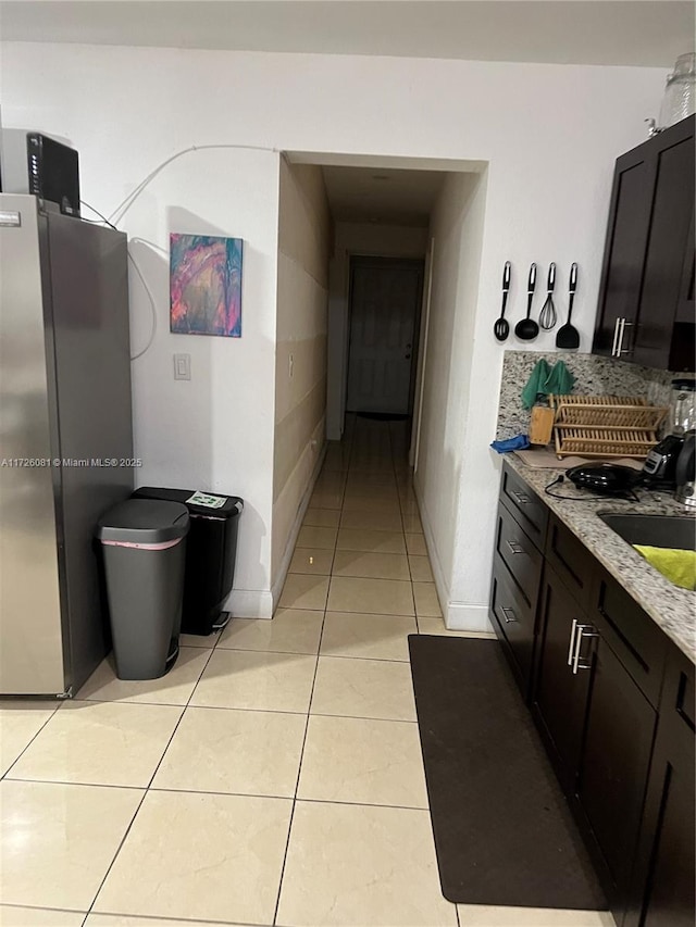 hallway with light tile patterned floors and sink