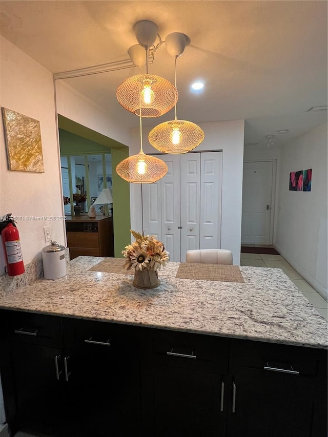 kitchen featuring light tile patterned flooring, light stone countertops, and hanging light fixtures