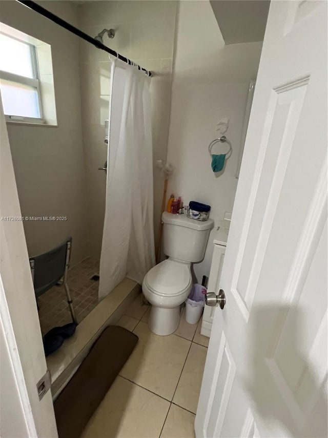 bathroom featuring tile patterned flooring, curtained shower, and toilet