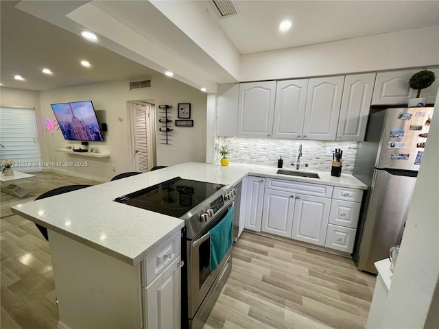 kitchen with kitchen peninsula, white cabinets, and appliances with stainless steel finishes