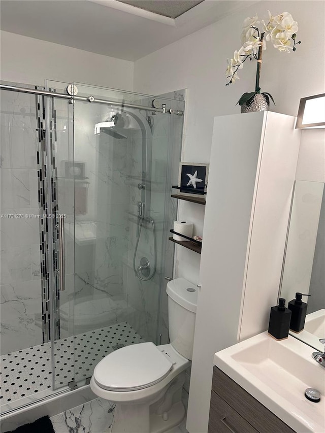 bathroom with walk in shower, vanity, and toilet