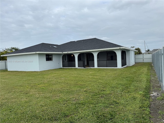 back of house featuring a yard and a sunroom