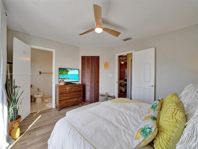 bedroom with ceiling fan, connected bathroom, light hardwood / wood-style floors, and a closet