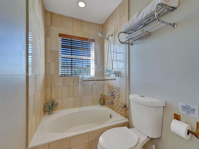 bathroom with tiled shower / bath combo and toilet