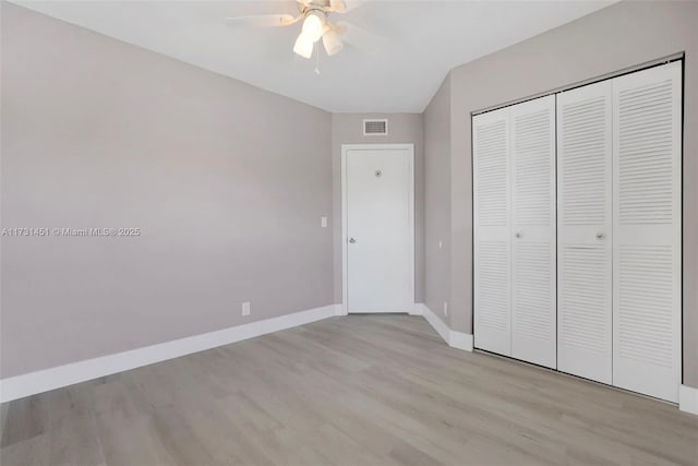 unfurnished bedroom with light hardwood / wood-style floors, a closet, and ceiling fan