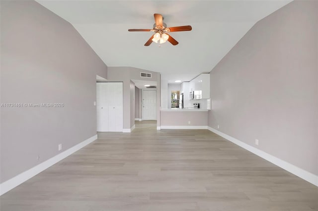 unfurnished living room featuring ceiling fan, lofted ceiling, and light hardwood / wood-style flooring