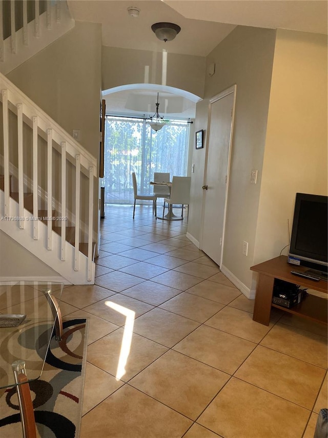 hall featuring a chandelier and light tile patterned floors